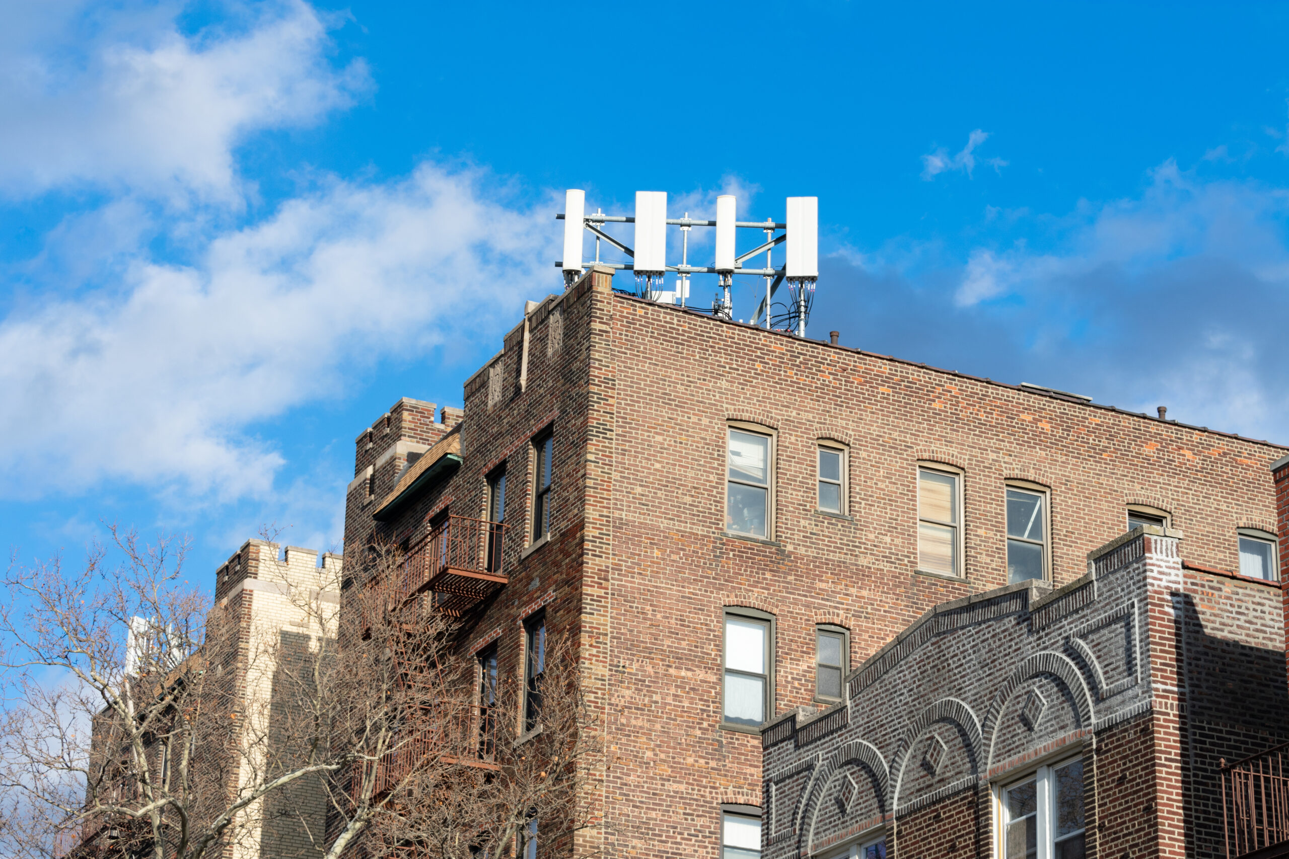 A modern cell site on the roof of an old brick residential building in New York City